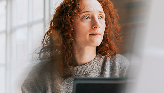 femme rousse assise au bureau avec ordinateur