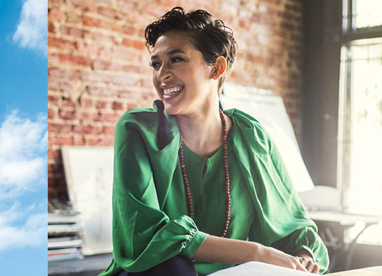 Smiling woman with green blouse and blue sky texture