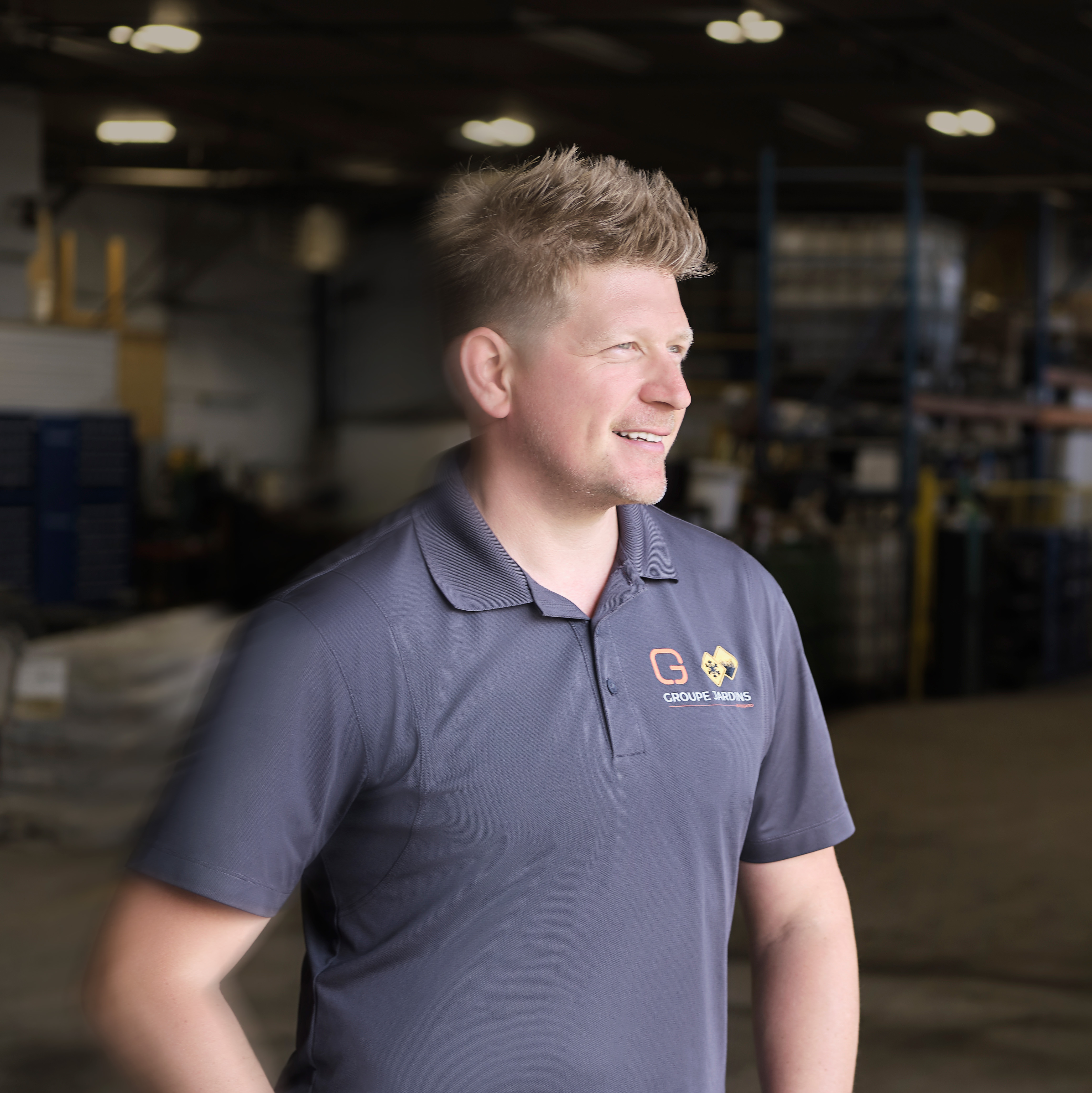Olivier Girard smiling and standing in warehouse of Groupe Jardins Brossard