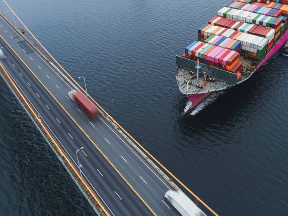 bateau de charge naviguant près d’un pont